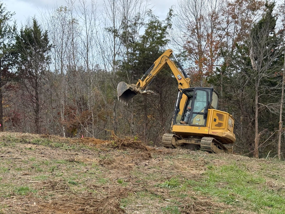 Mini-excavator clearing a cabin site