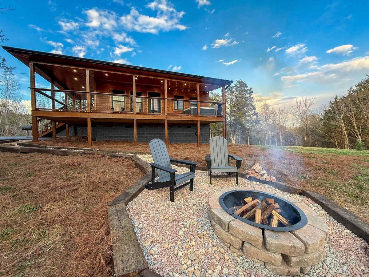 Gravel fire pit with chairs in front of a cabin